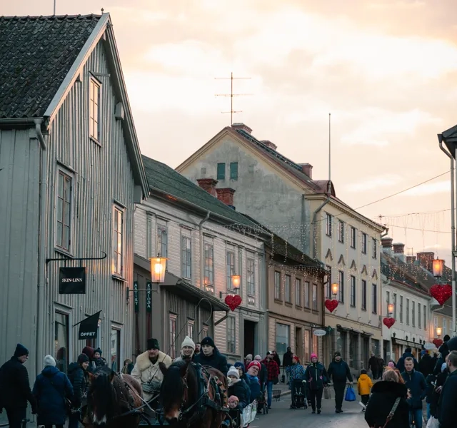 A crowd of people walking down a street next to tall buildings.