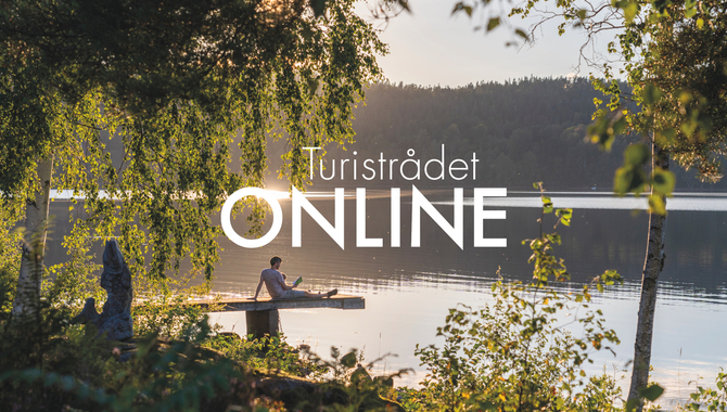 En man sitter på en båt på en sjö.