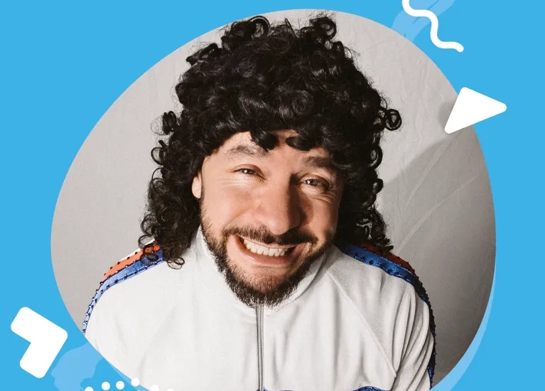 En man med lockigt hår klädd i vit skjorta.