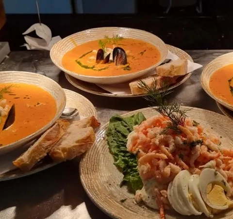 Ett bord täckt med tallrikar med mat och skålar med soppa.