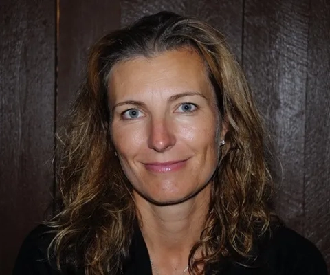 En kvinna med långt hår och svart skjorta.