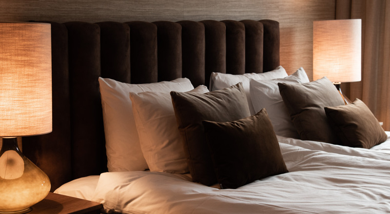 Ett sovrum med en stor säng och två lampor.