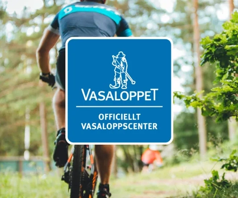 Logotypen för officiellt vasaloppscenter ovanpå en bild med ryggen på en cyklist utmed ett cykelspår.