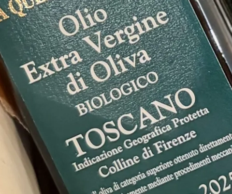 En vit skål fylld med flaskor med olivolja.