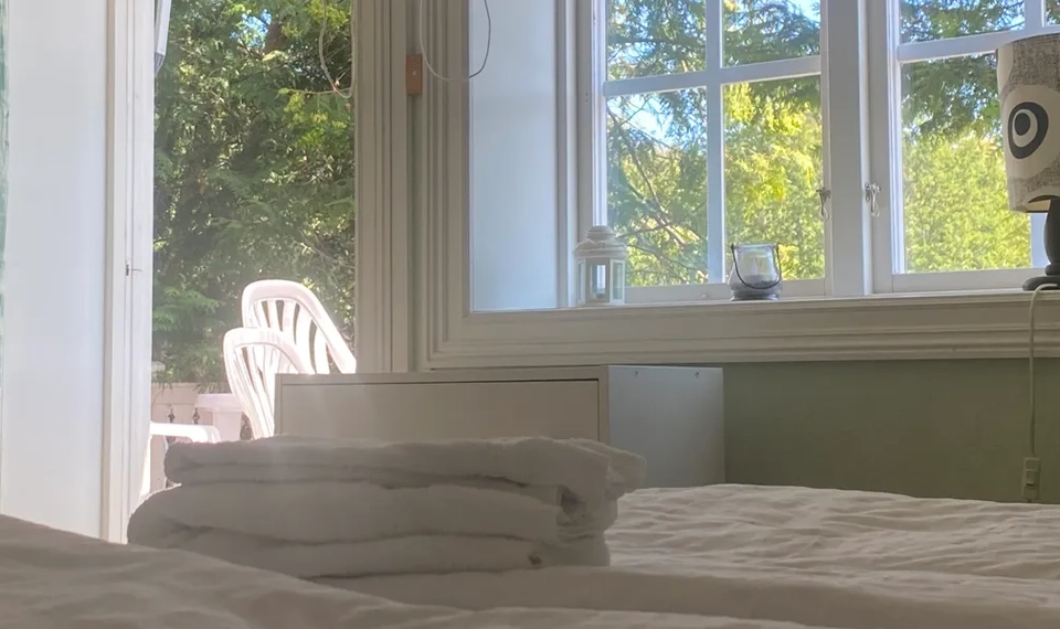 En säng med en hög vikta handdukar på.