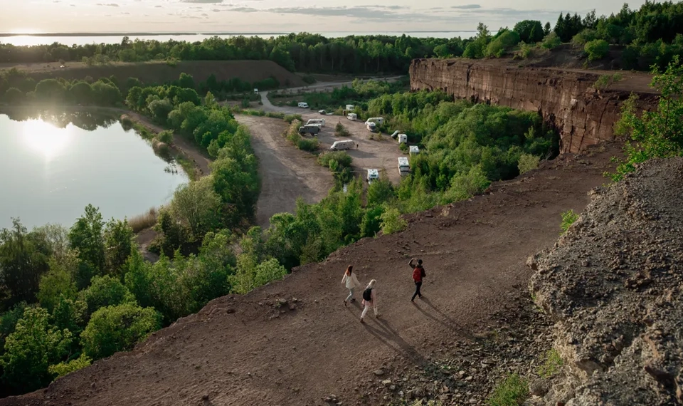 Tre människor promenerar vid Stora Stenbrottet, Kinnekulle med utsikt över Vänern