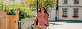 A woman riding a bike down a street.