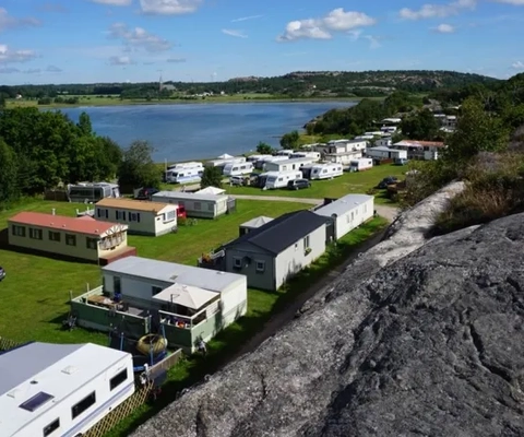 En flygbild av en campingplats med havet i bakgrunden.
