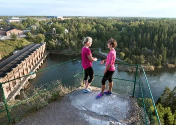 Två kvinnor som står vid utsiktspunkten Kopparklinten med utsikt över Göta älv.