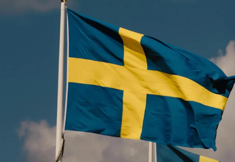 Två flaggor som vajar i vinden på en molnig dag.