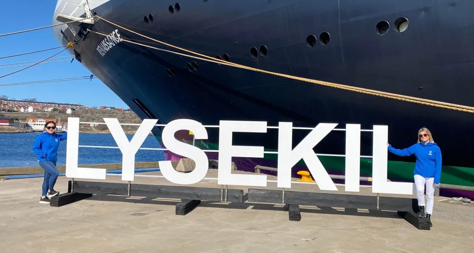 Några personer som står bredvid ett stort fartyg.