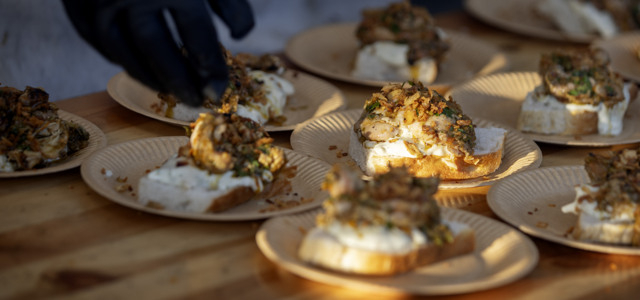 Ett träbord med tallrikar med mat på.