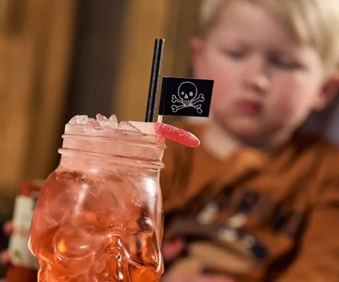 En ung pojke som sitter vid ett bord med glas saft  framför sig.