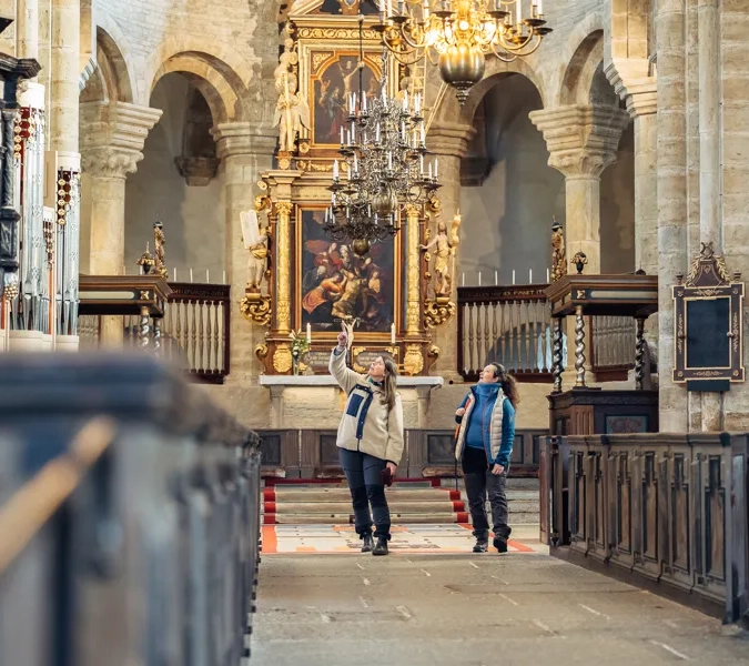 Två kvinnor inne i Varnhems Klosterkyrka