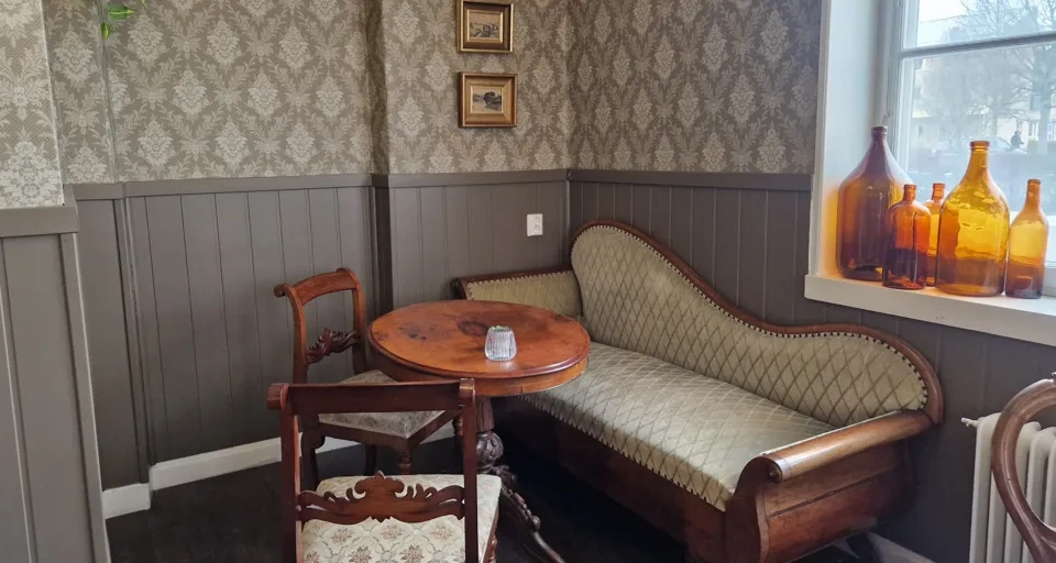 Ett rum med soffa, bord och stolar.