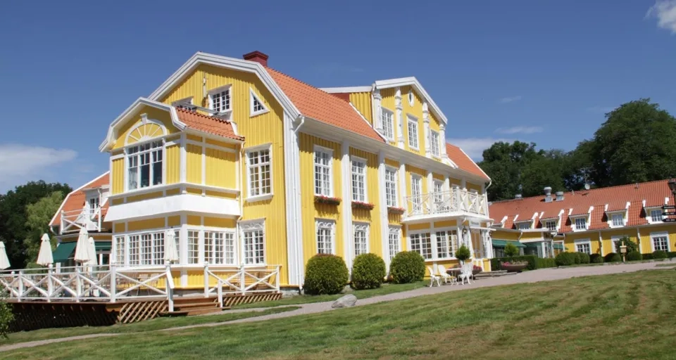 Ett stort gult hus med rött tak.