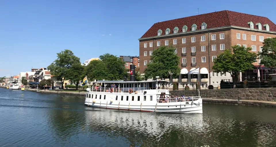 En stor vit båt som flyter på toppen av en flod.