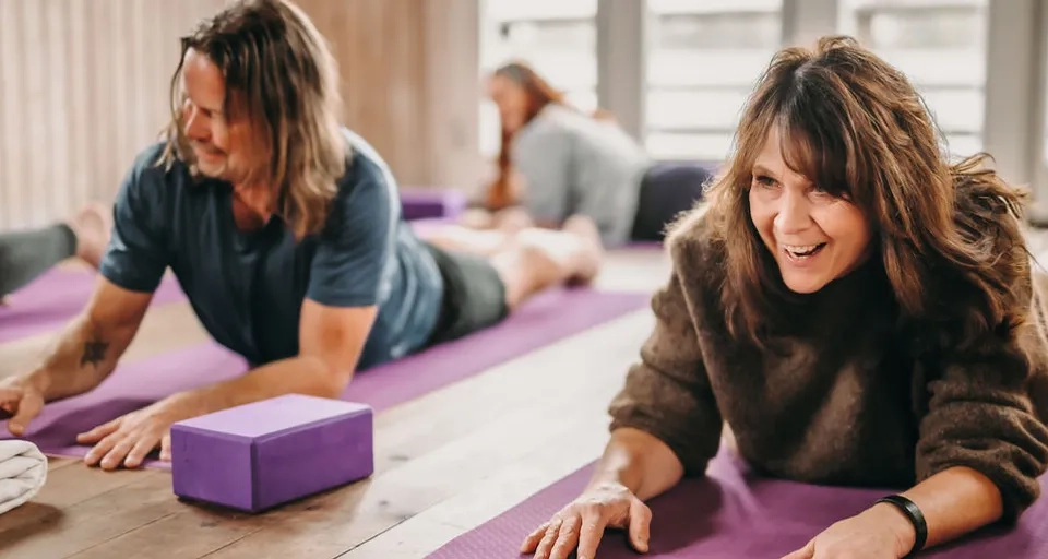 A couple of women laying on top of yoga mats.