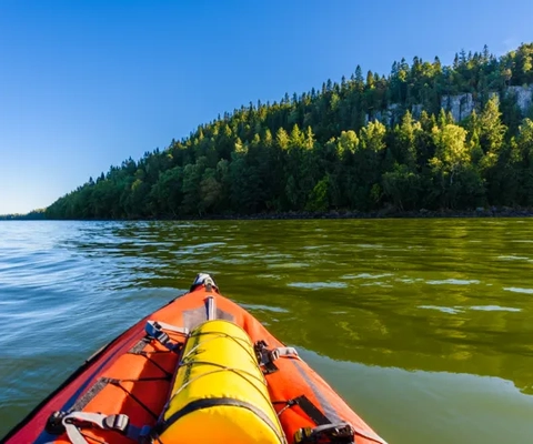 En kajak i mitten av en sjö med ett berg i bakgrunden.