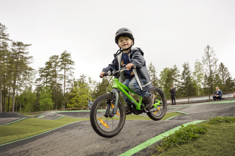 Boy riding a bike on a pump track.