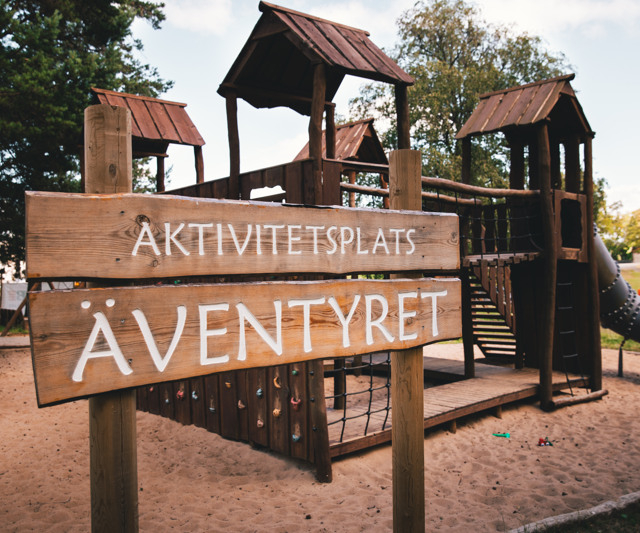 Sign showing the name of the activity area, with the area visible in the background.