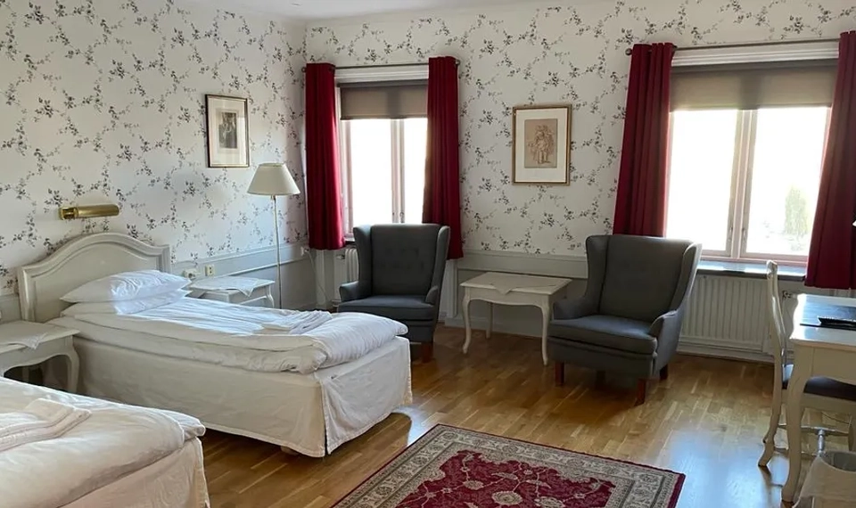 Vy över ett sovrum på Tidaholms stadshotell.