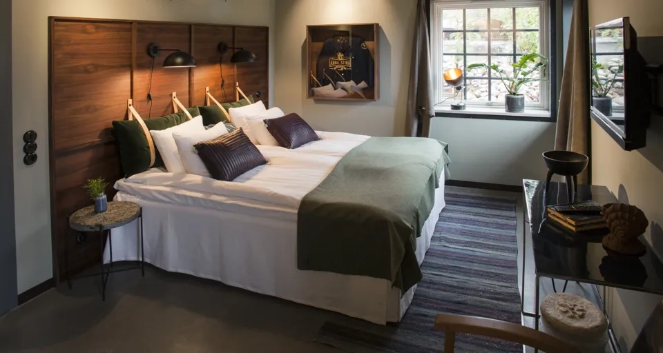 Ett sovrum med en stor säng och ett fönster.