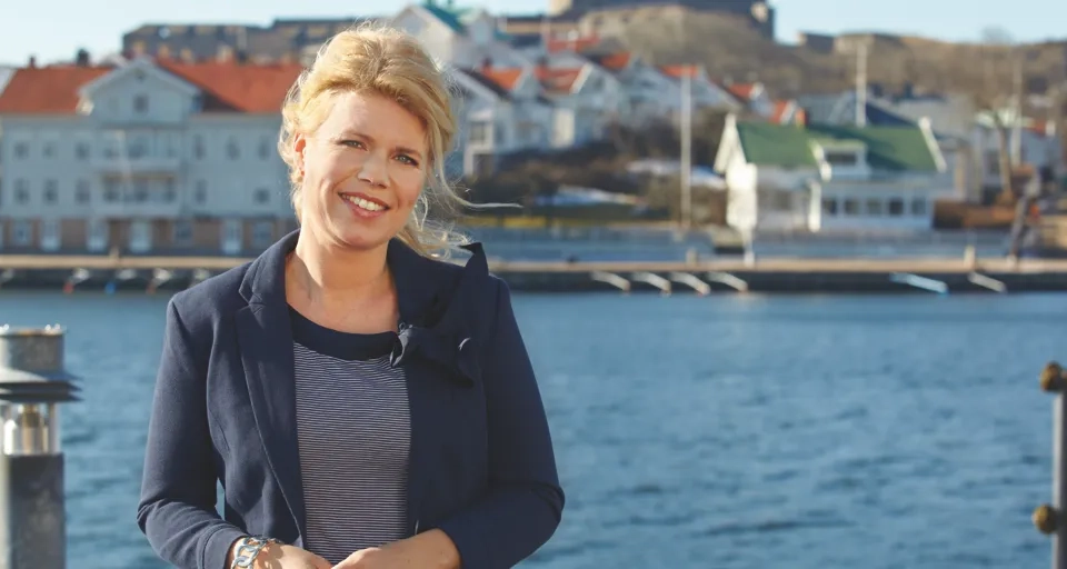 En kvinna som står bredvid ett vattendrag.