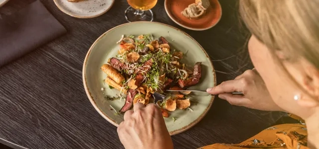 Kvinna som äter en maträtt.