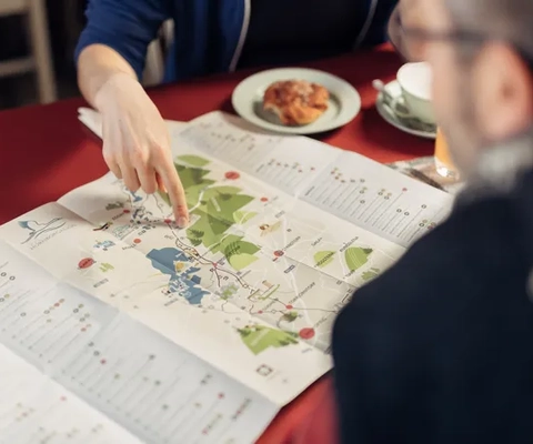 Två människor planerar sin vandring över en fika.