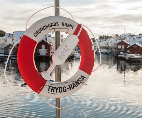En röd och vit livboj som sitter på toppen av en stolpe.