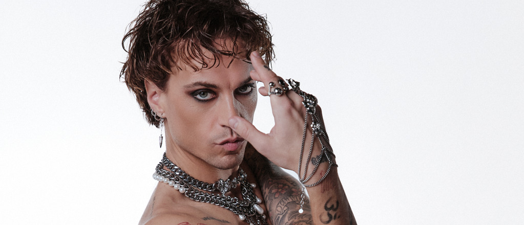 En man med tatueringar och piercingar på bröstet.