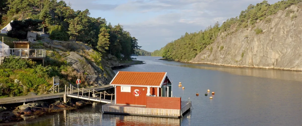 A houseboat docked at a dock on a lake.