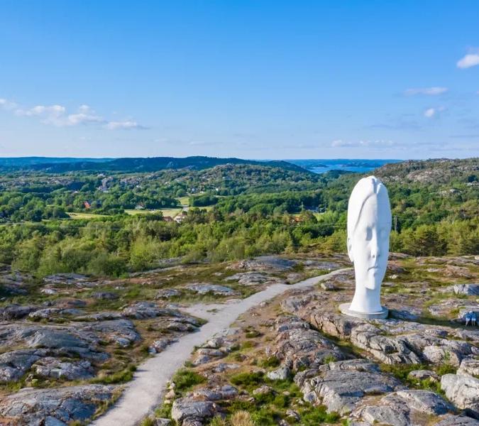 Eine Statue einer Person auf dem Gipfel eines Berges.