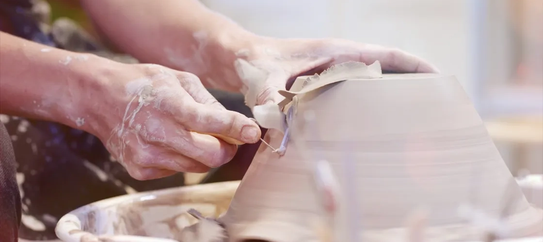 En hand drejar en skål, beskickar undersidan