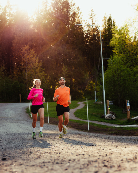 Två personer som springer på ett grusat motionsspår