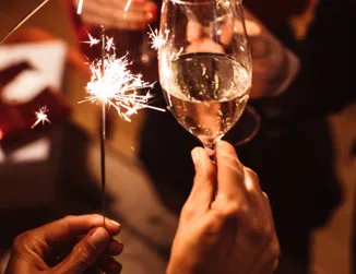 Personer står och skålar och håller i tomtebloss