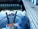 En person som sitter på en brygga intill ett vattendrag.