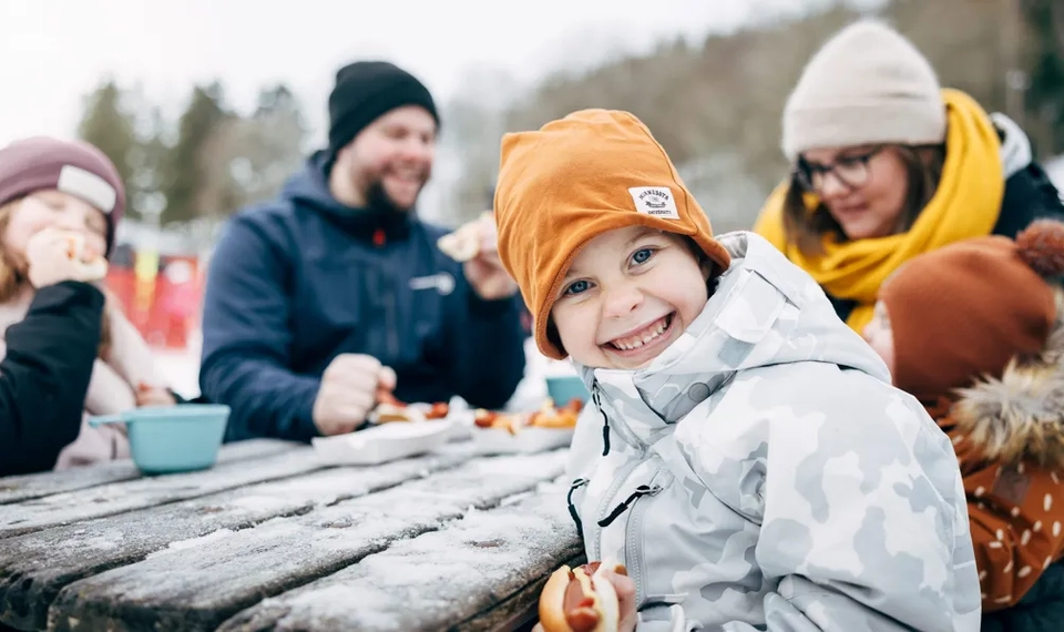 Familj som fikar vid en skidbacke