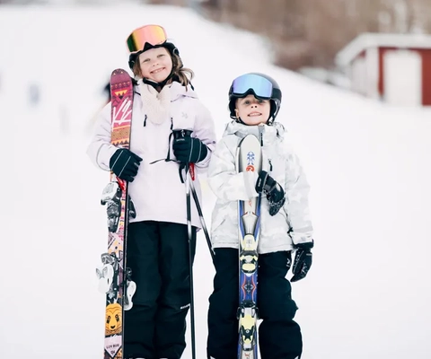 Några personer som står på toppen av en snötäckt sluttning.
