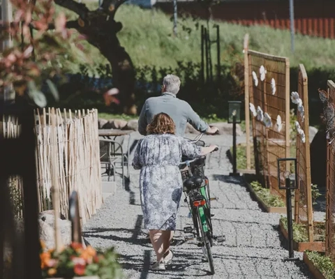 A man and a woman walking their bicycles at Kläpphagen, Koster.