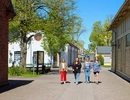 En grupp människor som går längs en gata intill en byggnad.