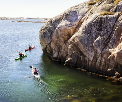 Två personer i kanoter paddlar på vattnet.