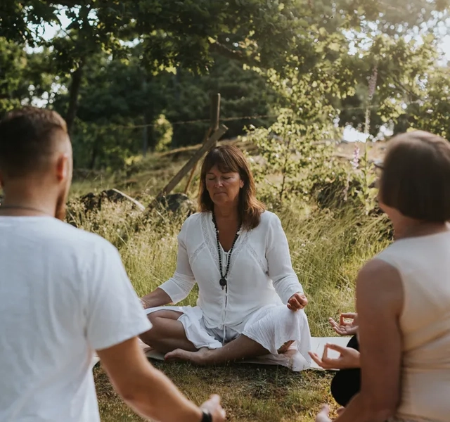 Människor som utövar yoga utomhus.