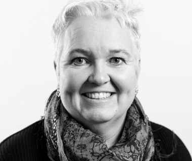 Ett svartvitt foto av en leende kvinna.