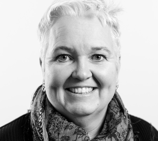 A black and white photo of a smiling woman.