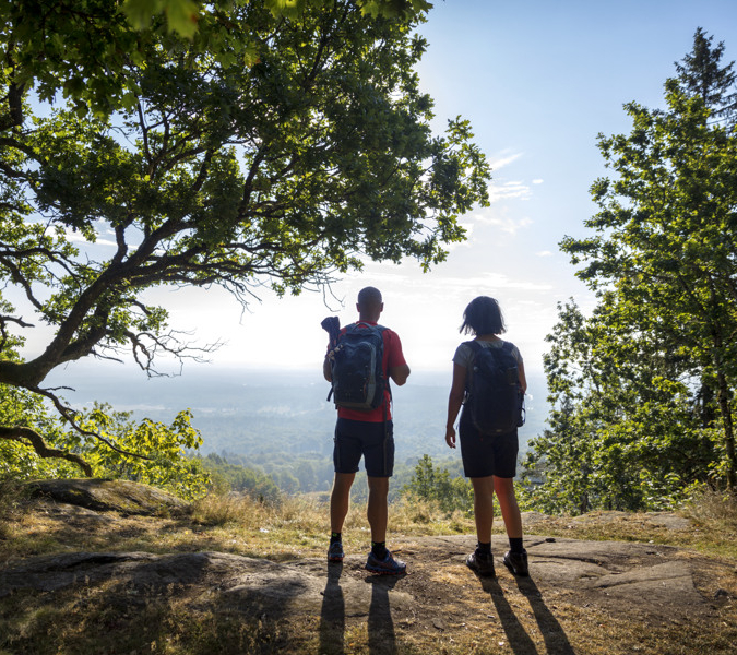 A couple of people standing on top of a hill.