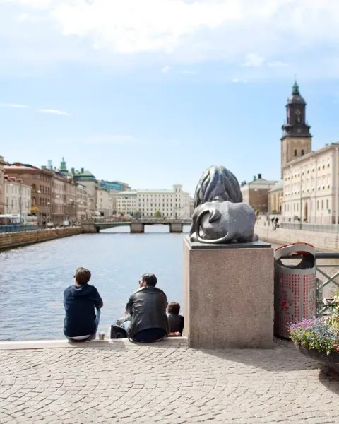 Några personer som sitter bredvid ett vattendrag.