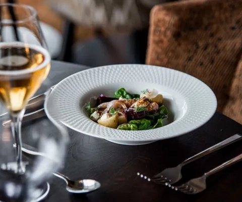 Dukat bord med vinglas och en tallrik med mat