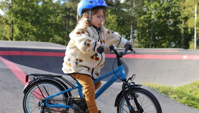 En liten flicka cyklar på en blå cykel.